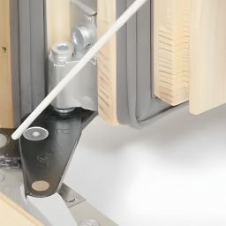 Smarowanie zawiasu ukrytego w systemie Roto NXC przy pomocy aplikatora – pielęgnacja okuć w oknie drewnianym.